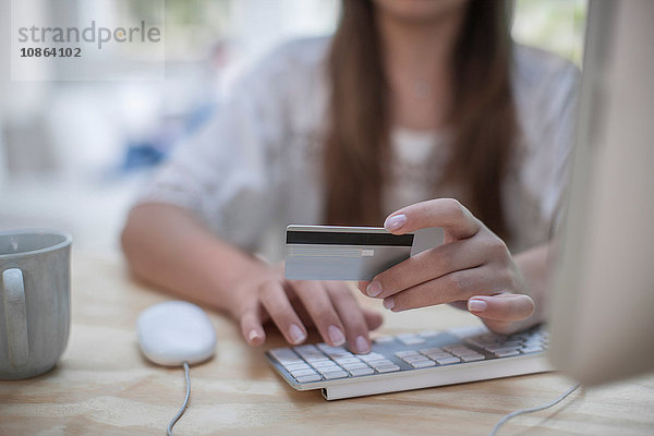 Frau  die beim Online-Shopping mit Kreditkarte bezahlt