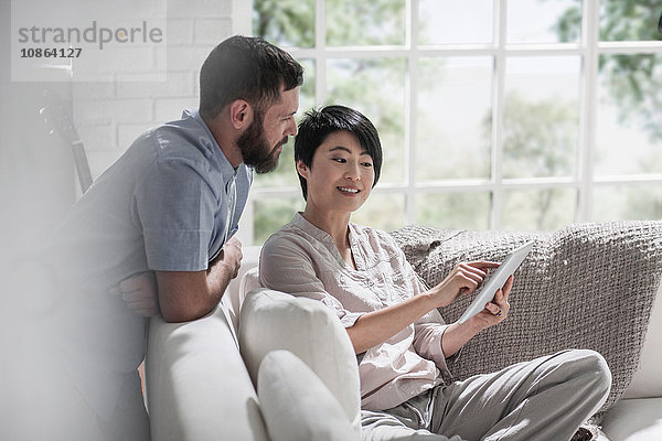 Ehepaar mit digitalem Tablett auf dem Sofa