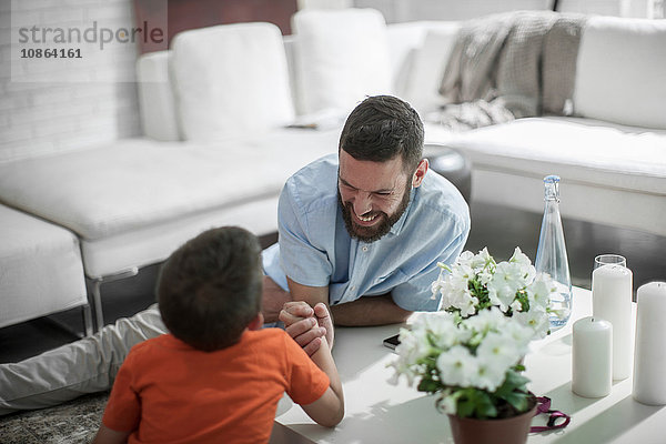 Armdrücken zwischen Vater und Sohn zu Hause