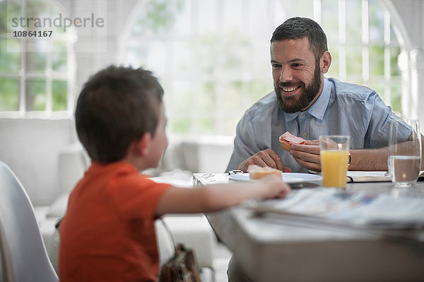 Vater und Sohn unterhalten sich am Esstisch