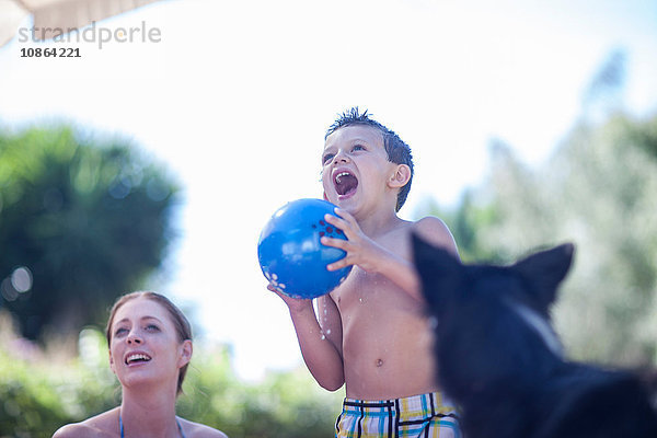 Mutter und Sohn spielen Ball  Hund schaut zu