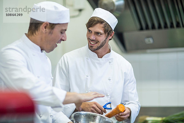 Köche unterhalten sich und bereiten das Essen in der Küche vor