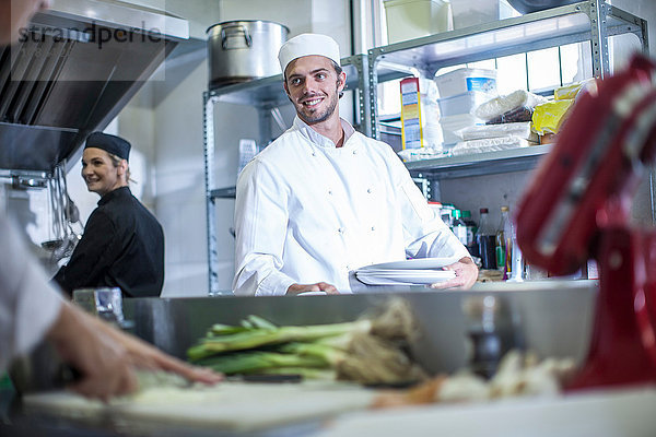 Köche unterhalten sich und bereiten das Essen in der Küche vor