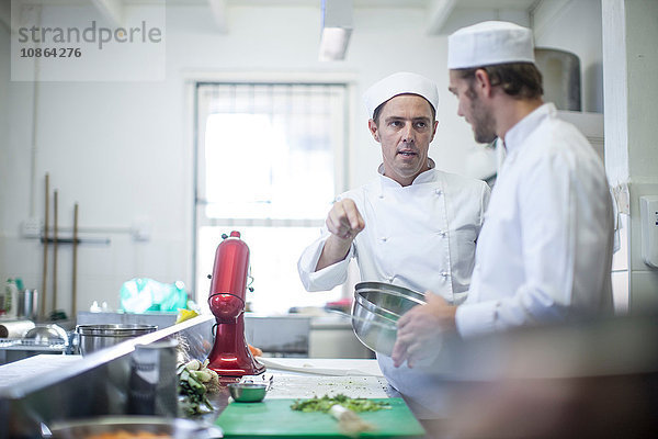 Köche unterhalten sich und bereiten das Essen in der Küche vor