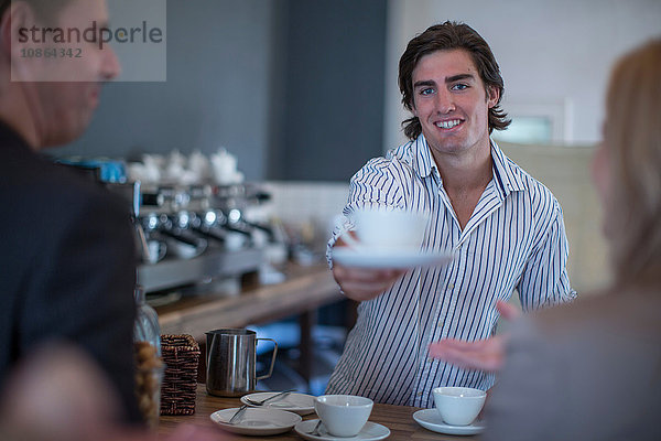 Barista serviert Kaffee an Kunden im Café