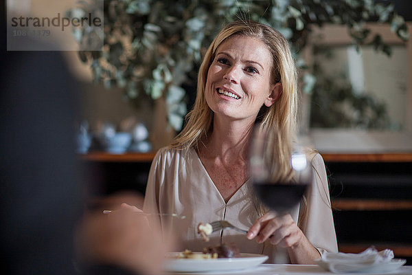 Frau speist und plaudert mit Freundin im Restaurant