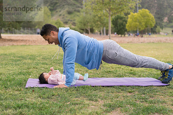 Vater trainiert mit Baby im Park