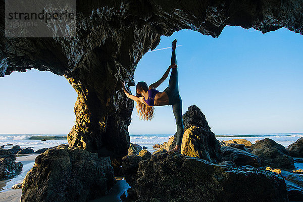 Junge Balletttänzerin steht auf einem Bein in einer Meereshöhle  Los Angeles  Kalifornien  USA