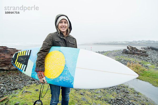 Porträt einer Surferin mit Surfbrett an der Küste  Seaside  Oregon  USA