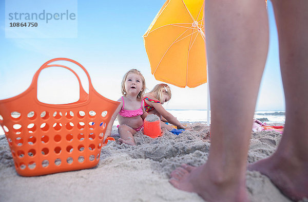 Zwei Schwestern am Strand sitzend  Vaters Beine  Kapstadt  Südafrika