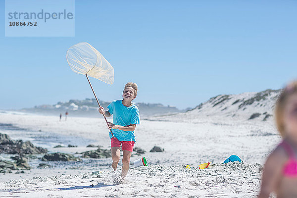 Junge läuft am Strand mit Fischernetz  Kapstadt  Südafrika