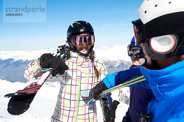 Drei Jugendliche mit Skiern