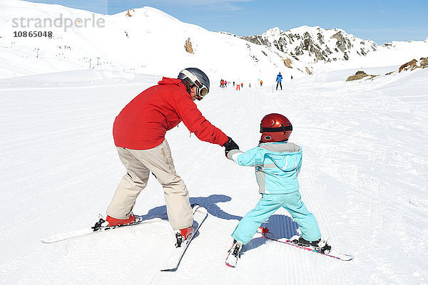 Mutter  die dem Sohn das Skifahren beibringt  Rückansicht