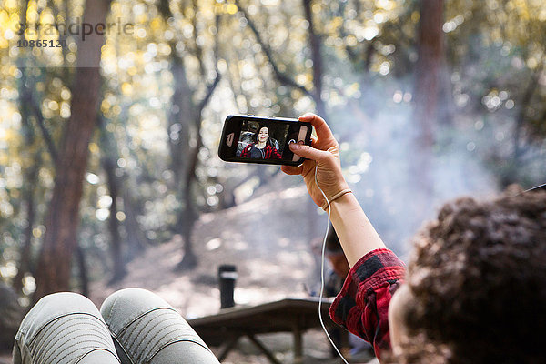 Über-die-Schulter-Ansicht einer jungen Wanderin  die mit ihrem Smartphone im Wald unterwegs ist  Arcadia  Kalifornien  USA