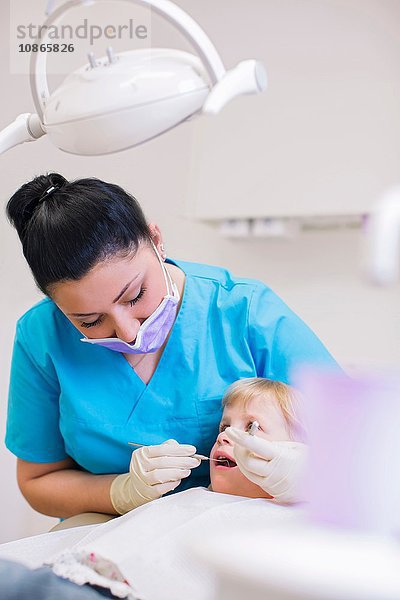 Mädchen auf Zahnarztstuhl bei zahnärztlicher Untersuchung