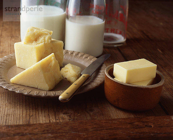 Käse-  Butter- und Milchflaschen auf Holztisch