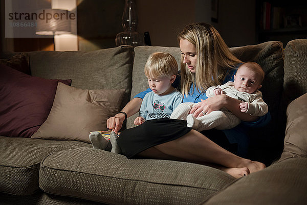 Mutter entspannt sich mit Sohn und Kleinkind auf dem Sofa
