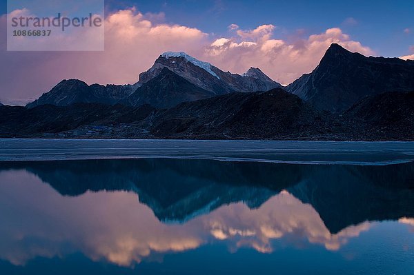 Berge spiegeln sich im noch ländlichen See