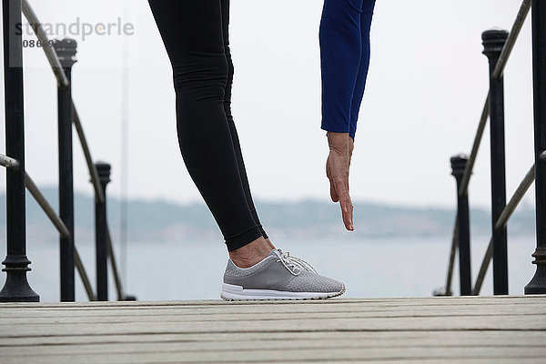 Reife Frau im Freien  Sport treiben  Zehen berühren  niedrige Sektion