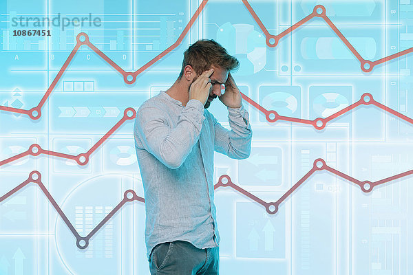 Mann berührt die Schläfen  betonter Ausdruck  grafischer Bildschirm mit Daten hinter ihm