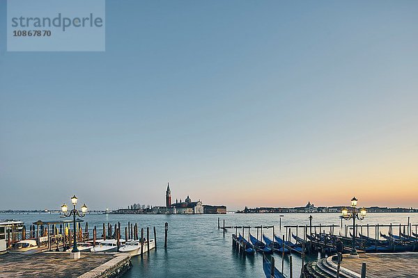 Fernansicht von Reihen vertäuter Gondeln am Wasser in der Abenddämmerung  Venedig  Italien