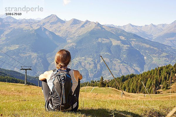 Rückansicht einer Wanderin  die über die Berglandschaft blickt  Aostatal  Aosta  Italien