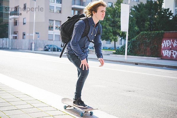 Junge männliche Skateboarder Skateboarder auf dem Bürgersteig