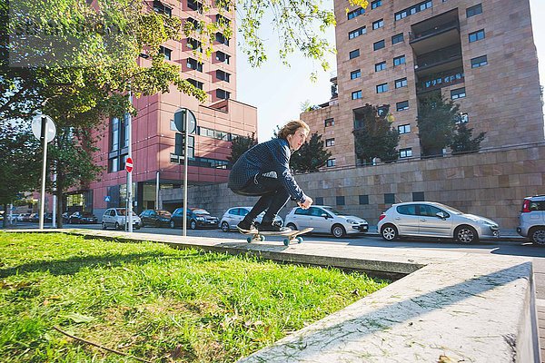 Junge männliche Skateboarder Skateboarder an der Stadtmauer