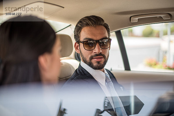 Junger Geschäftsmann und Frau unterhalten sich auf dem Rücksitz eines Autos  Dubai  Vereinigte Arabische Emirate