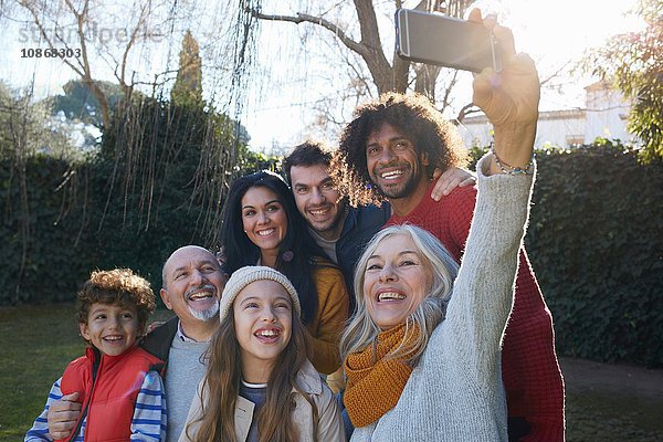 Mehrgenerationen-Familie drängte sich mit Smartphone zusammen  um sich selbst zu nehmen  lächelnd