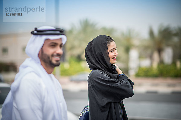 Paar aus dem Nahen Osten in traditioneller Kleidung auf der Straße  Dubai  Vereinigte Arabische Emirate