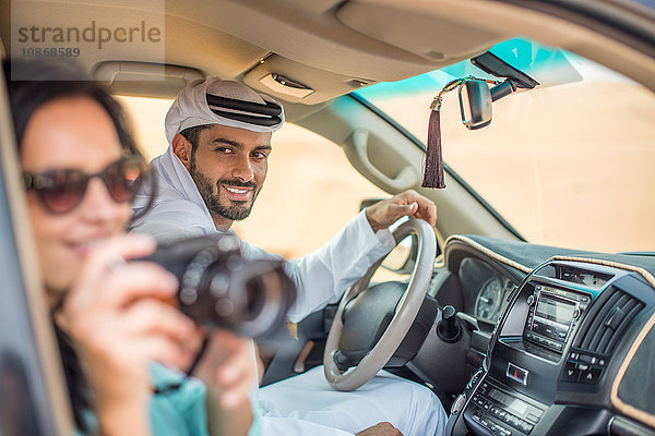 Weibliche Touristin im Geländewagen in der Wüste beim Fotografieren  Dubai  Vereinigte Arabische Emirate