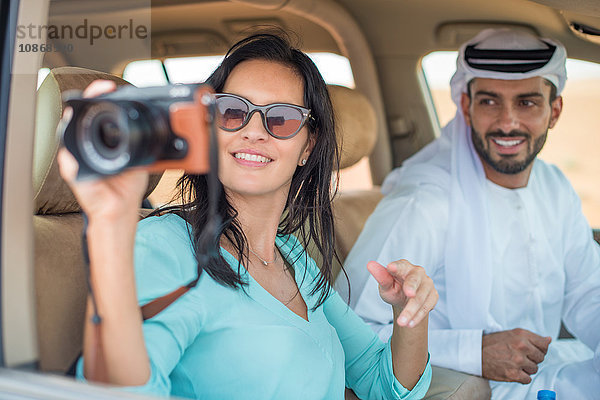 Weibliche Touristin im Geländewagen in der Wüste beim Fotografieren  Dubai  Vereinigte Arabische Emirate