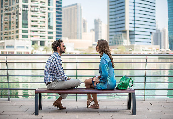 Touristenpaar sitzt am Wasser und unterhält sich  Dubai  Vereinigte Arabische Emirate