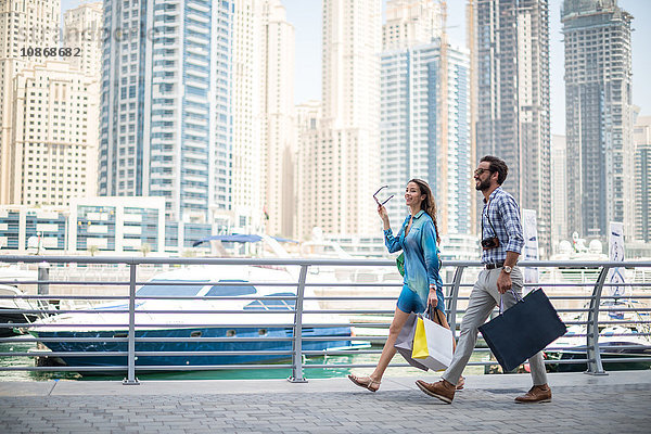 Paar schlendert am Wasser mit Einkaufstaschen  Dubai  Vereinigte Arabische Emirate