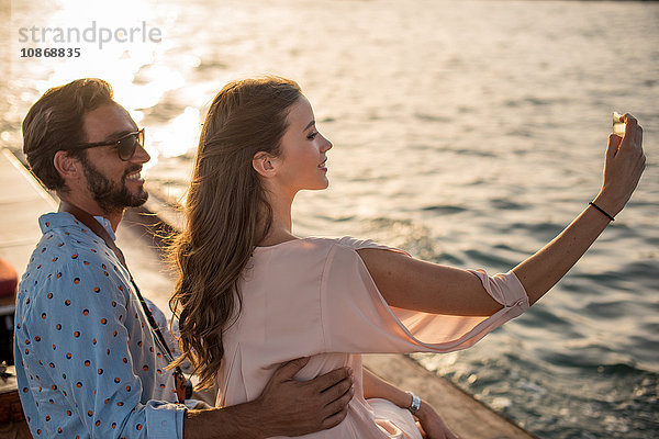 Romantisches Paar mit Smartphone-Selfie auf dem Boot im Yachthafen von Dubai  Vereinigte Arabische Emirate