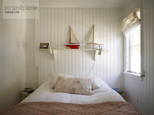 Schlafzimmer mit weißer Holzverkleidung und Bett