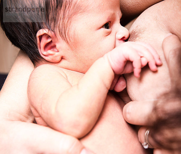 Nahaufnahme eines Säuglings  der von einer Mutter im mittleren Erwachsenenalter gestillt wird