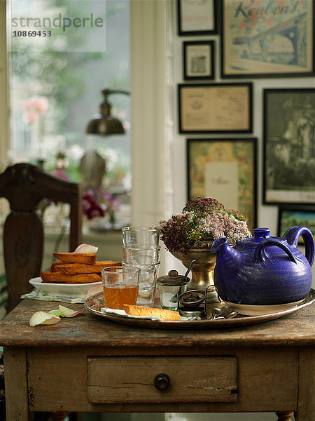 Oldtimer-Tablett auf dem Schreibtisch mit Gläsern mit Tee und Teekanne