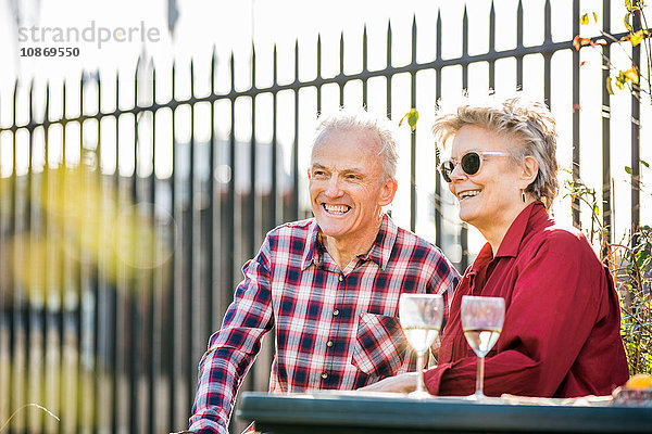 Seniorenpaar auf dem Dachgarten der Stadt entspannt sich bei Weißwein