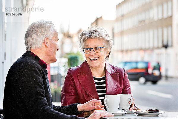 Romantisches Seniorenpaar im Straßencafé beim Händchenhalten