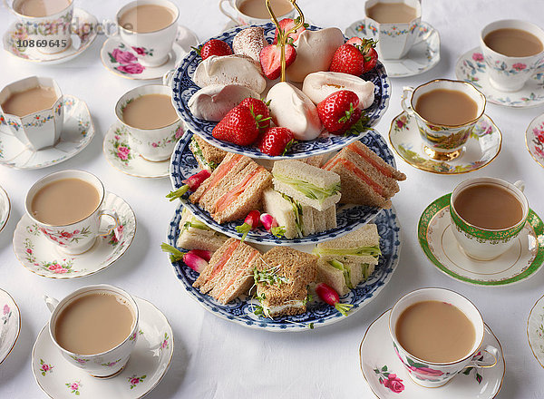 Klassische Teetassen und Sandwiches auf Kuchenständer für den Nachmittagstee