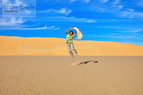 Mittelgroßer erwachsener Mann beim Springen  Großes Sandmeer  Ägypten  Afrika