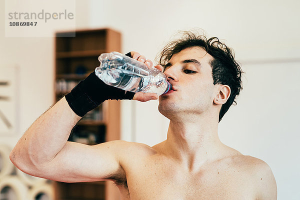 Mann trinkt Wasser aus der Flasche