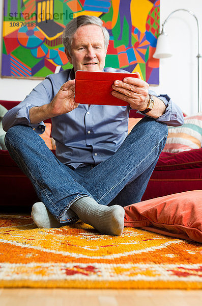 Mann benutzt digitales Tablett zu Hause