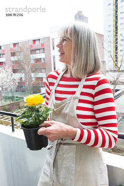 Frau gärtnert auf dem Balkon