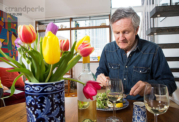 Mann genießt die Mahlzeit am Esstisch