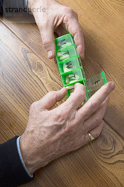 Mann nimmt Medikamente aus der Pillenschachtel