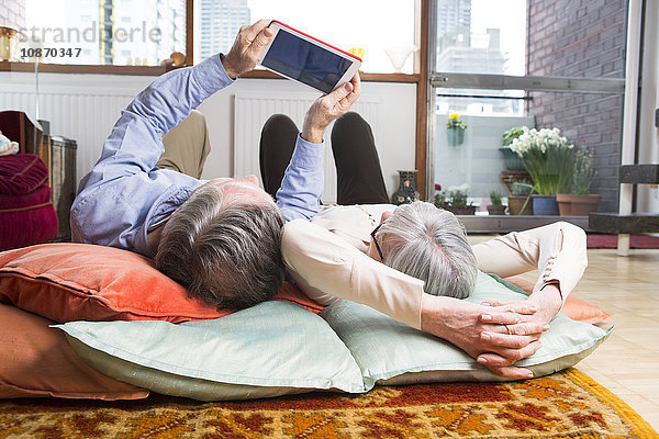 Paar mit digitalem Tablett auf dem Boden