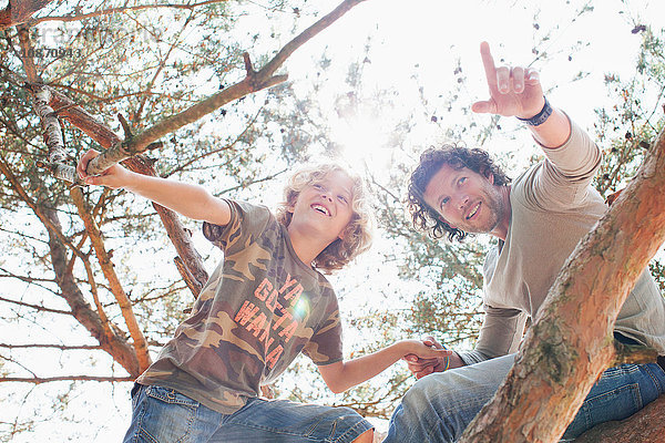 Vater und Sohn klettern auf Baum